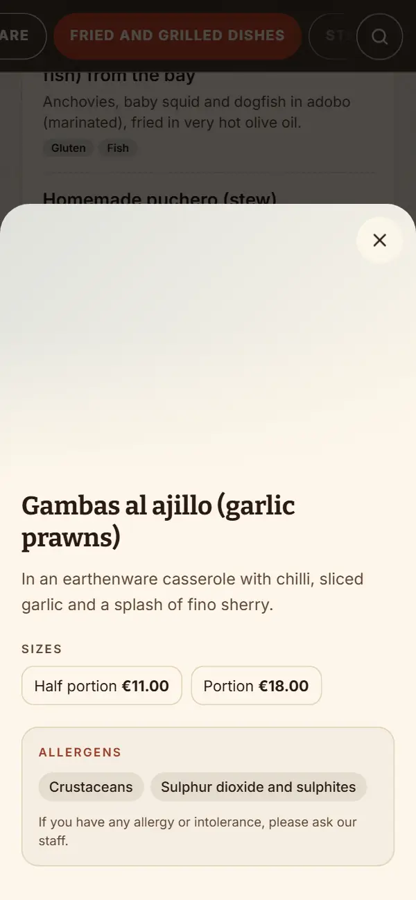 Ficha en inglés de las Gambas al ajillo (garlic prawns): Half portion y Portion con su precio y los alérgenos Crustaceans y Sulphur dioxide and sulphites